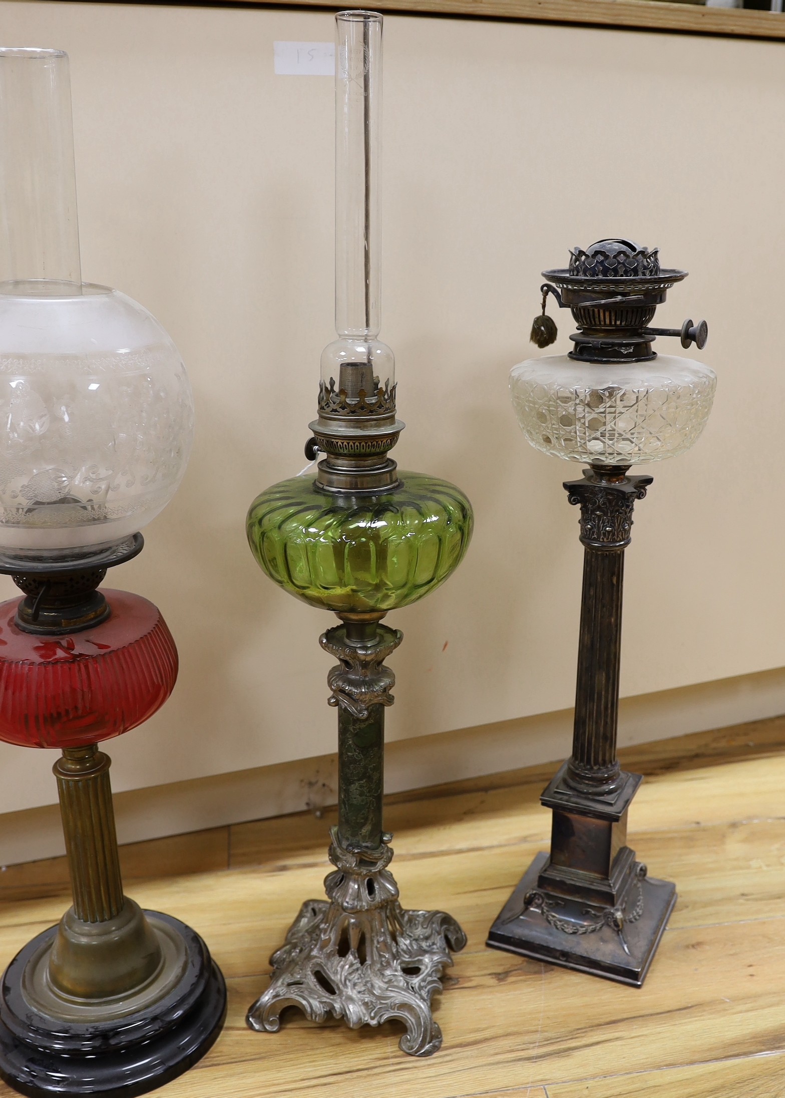 A Victorian plated oil lamp with glass reservoir, together with two others